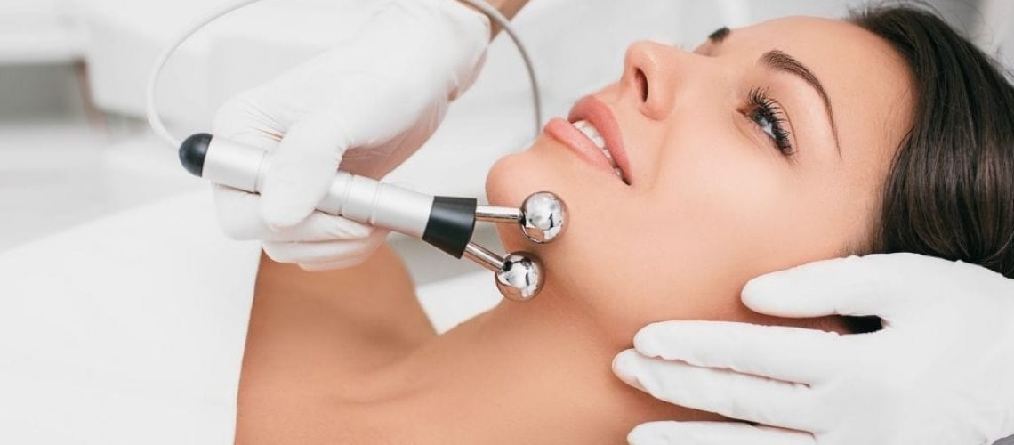 woman getting a microcurrent facial with a special device